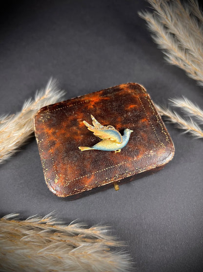 An enamel and diamond dove bird pendant, on an antique box