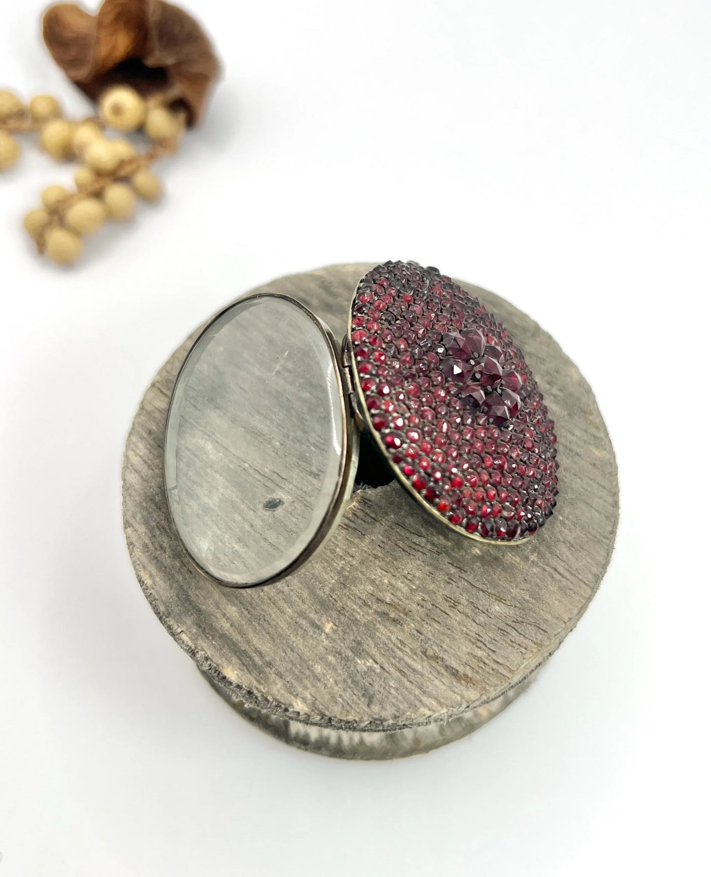 An antique oval locket encrusted with garnets, open