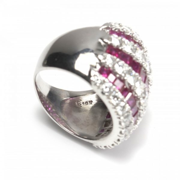 Contemporary Ruby and Diamond Bombe Cocktail Ring; seven alternating rows of 3.50cts calibre-cut rubies and 2.50cts round brilliant cut diamonds, claw and channel set in 18ct white gold, Circa 1990