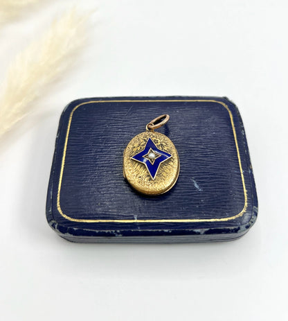 An oval yellow gold locket with a blue enamel star and seed pearl centre