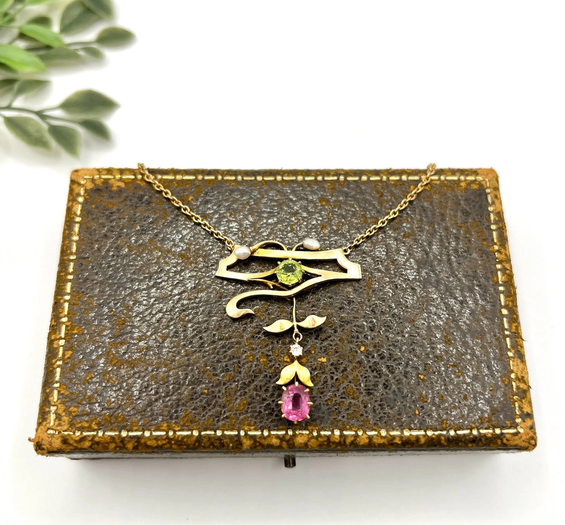 A yellow gold pendant necklace with pearls, a peridot, a diamond and a pink tourmaline drop