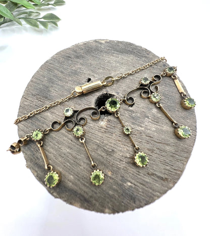 A yellow gold swag necklace with peridot drops