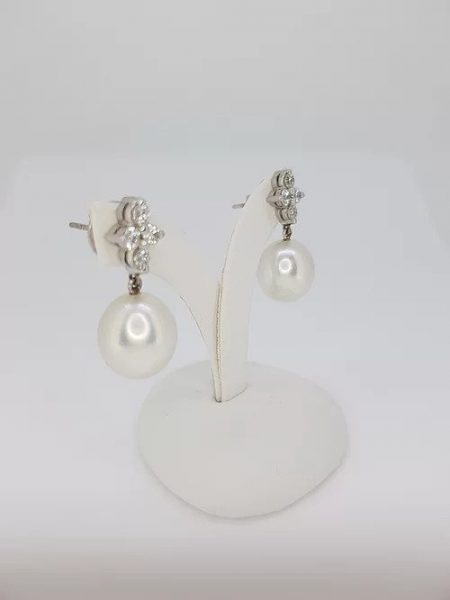 South Sea Pearl and Diamond Drop Earrings; featuring 13.5mm South Sea pearls suspended from diamond-set quatrefoil studs, 1.04 carat total, in 18ct white gold