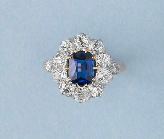 Antique Victorian Sapphire and Old Cut Diamond Cluster Ring; central 1.77ct oval cut untreated gorgeous vibrant blue sapphire surrounded by ten old cut diamonds totalling 2 carats, with diamond set shoulders in bullet shaped bezels, in 18ct rose gold. Made in France, late 19th century, Circa 1890