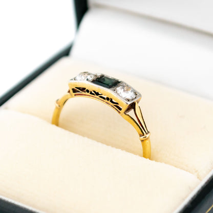 A three stone sapphire and diamond ring in yellow and white gold, in a ring box