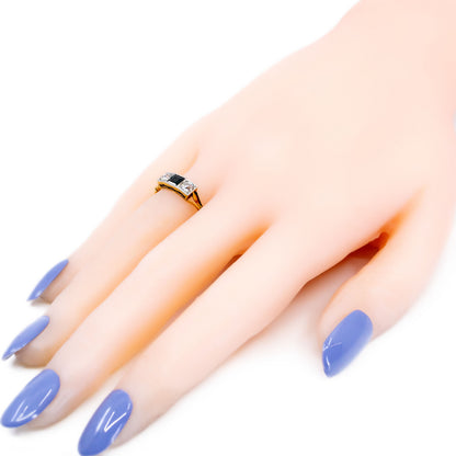 A three stone sapphire and diamond ring in yellow and white gold, modelled on a hand