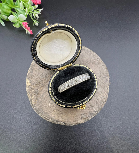 A platinum full eternity ring with round diamonds, in a ring box