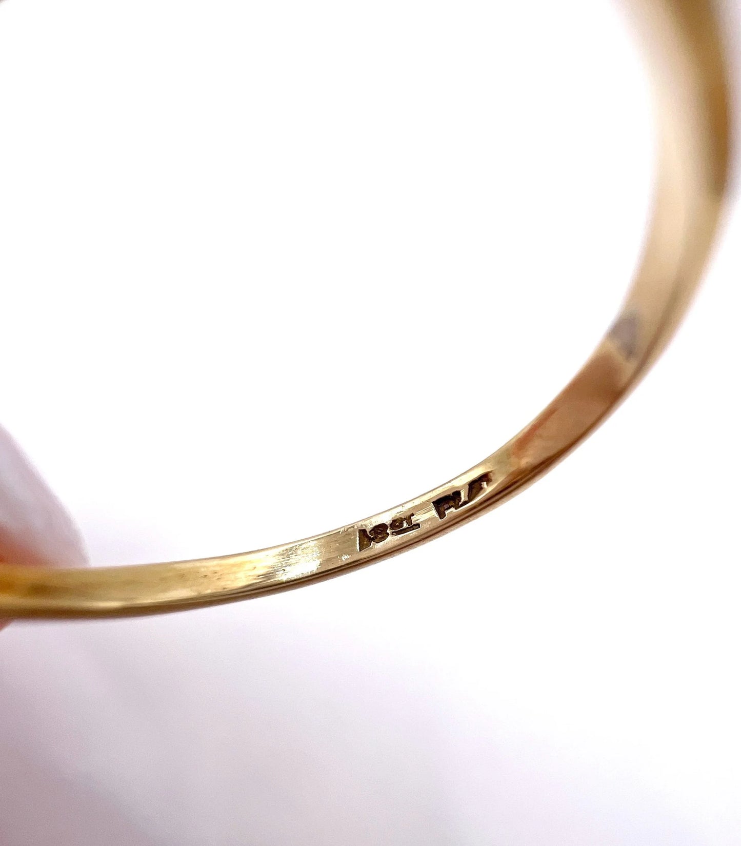 Close-up of an 18CT PLAT stamp inside a yellow gold ring shank