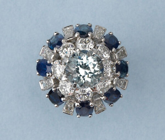 Vintage Aquamarine, Sapphire and Diamond Bombe Ring in Platinum; central 3.82ct round faceted light blue aquamarine surrounded by a double border of mixed-cut diamonds and sapphires, American, Circa 1950