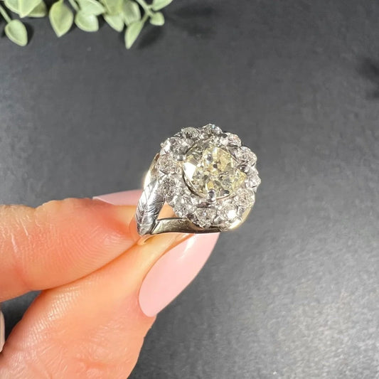 A diamond cluster ring in two tone gold, held in a hand