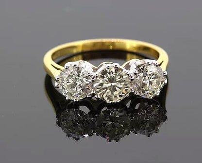 Three Stone Diamond Ring; A classic diamond trilogy ring featuring three round brilliant-cut diamonds totaling 2.06 carats, claw-set, 18ct yellow gold band.