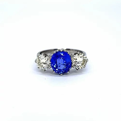 Sapphire and Diamond Three Stone Ring; central 2.60 carat oval faceted sapphire flanked either side by a round brilliant-cut diamond. Mounted in platinum. Diamonds total 1.50 carats