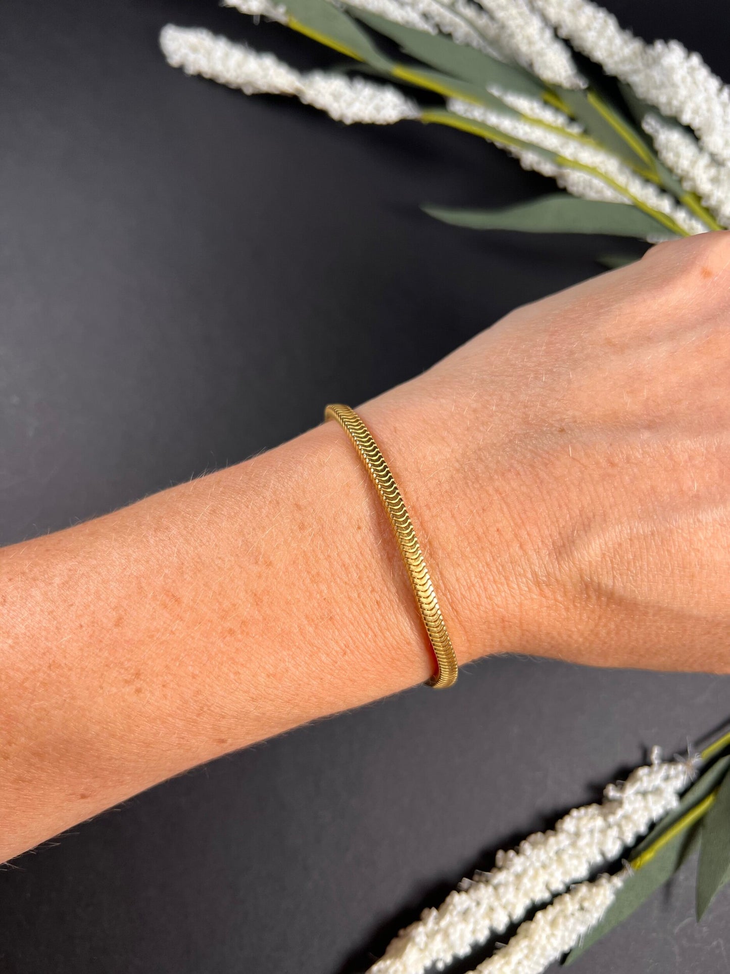 A yellow gold snake link bracelet, modelled on a wrist