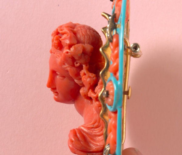 18th Century Carved Coral Cameo Brooch of Bacchante, a follower of Bacchus, framed by carved coral knots, rose-cut diamond ribbons, carved coral flowers and blue enamel. From celebrity jeweler, Fred Leighton’s private collection.