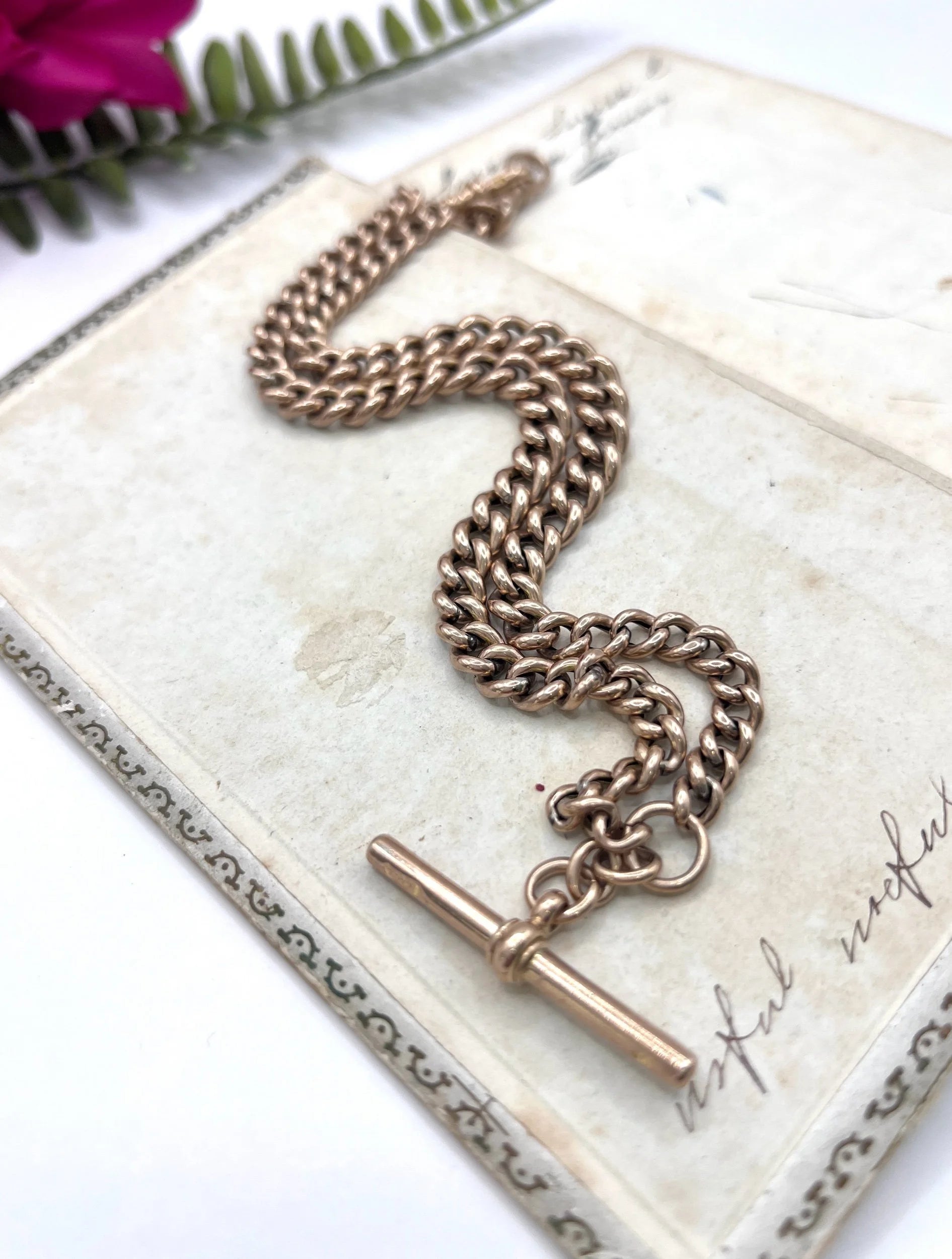 A rose gold curb link Albert chain with t-bar