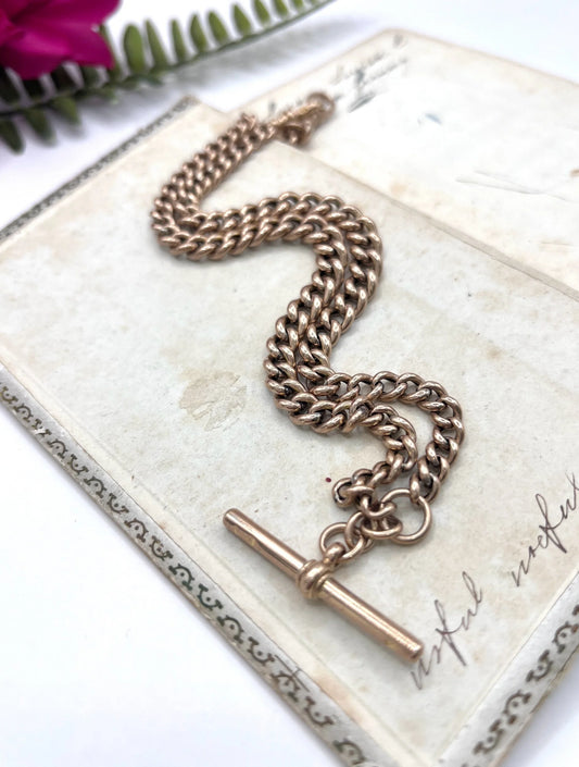 A rose gold curb link Albert chain with t-bar