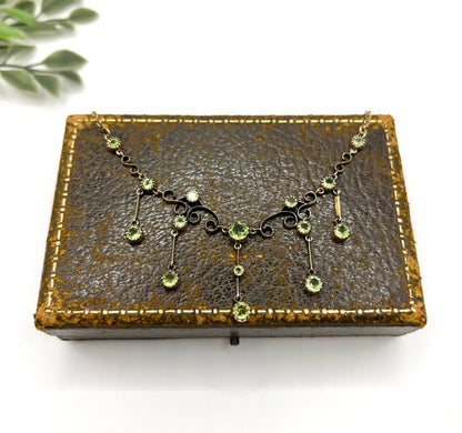 A yellow gold swag necklace with peridot drops