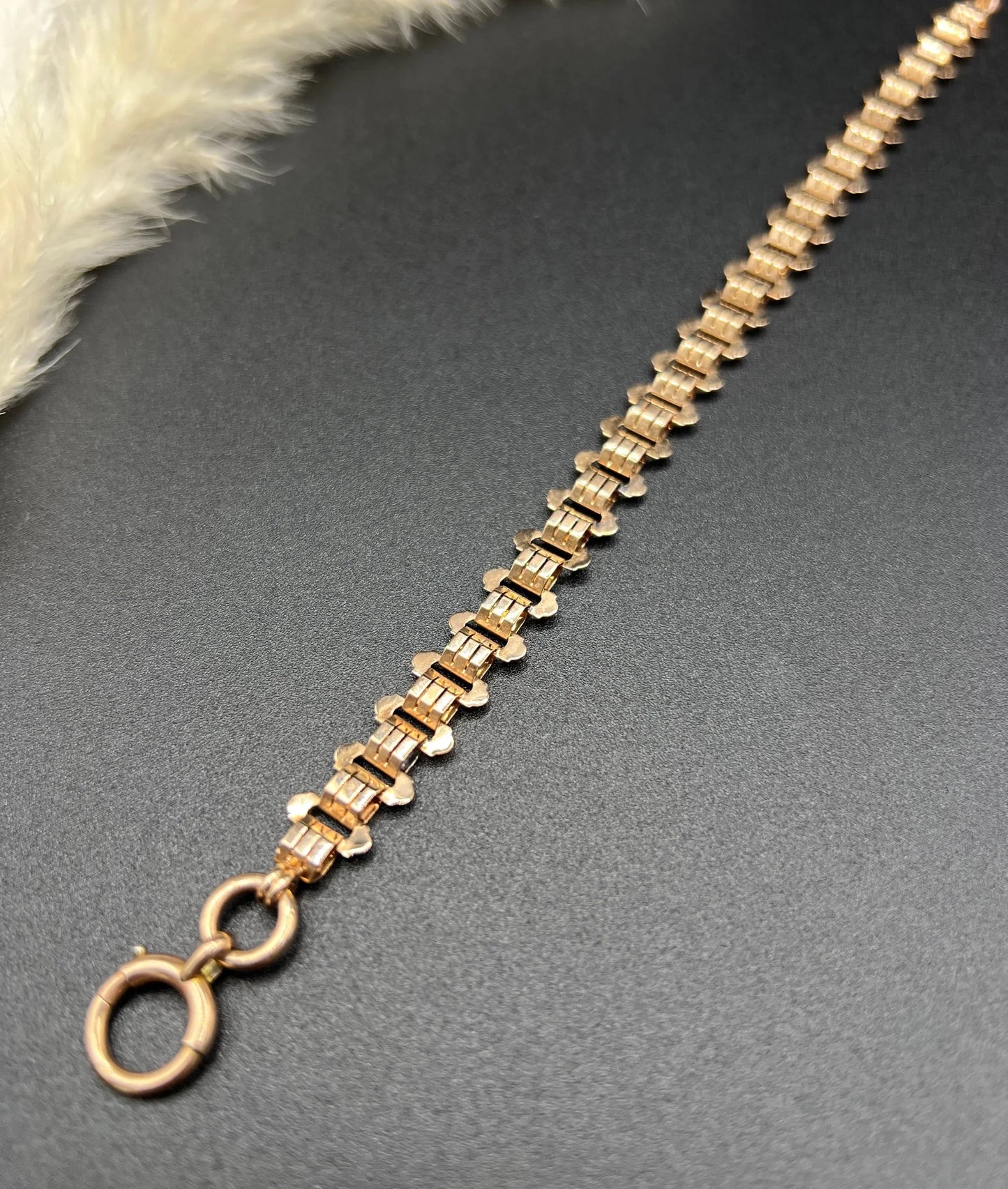 A rose gold fancy link bracelet with a bolt ring clasp