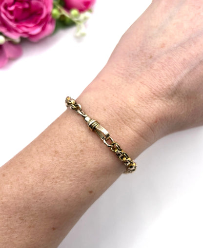 A gold round link bracelet with a lobster claw clasp, modelled on a wrist