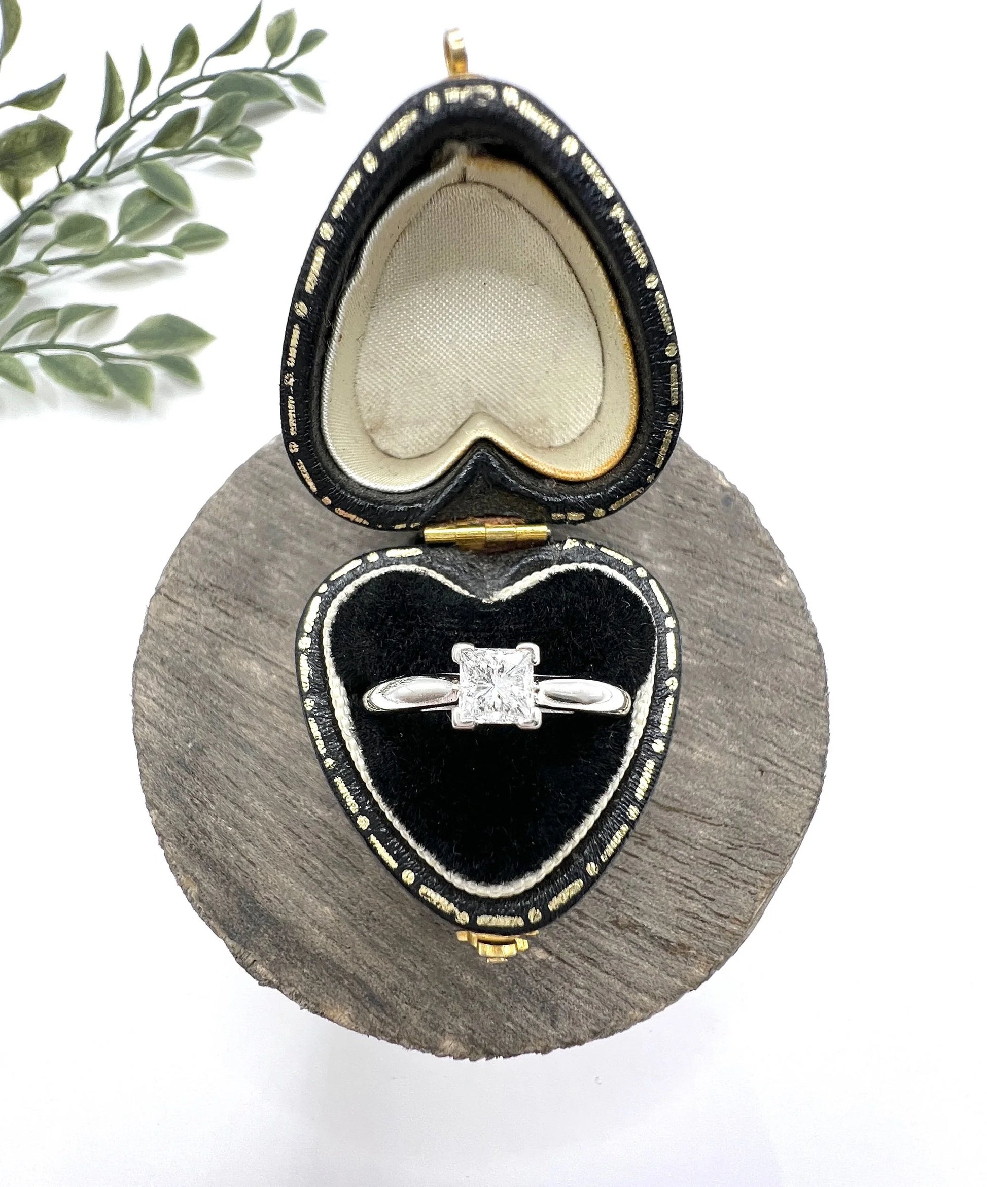 A princess cut diamond solitaire ring in platinum, in a heart-shaped ring box