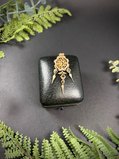 A yellow gold pendant with old cut diamonds, on a black antique box