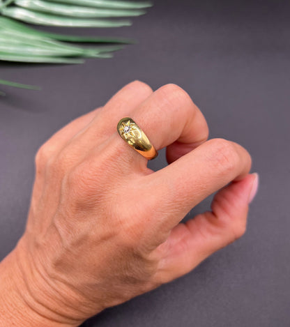 A single stone old cut diamond gypsy band ring in yellow gold, modelled on a hand