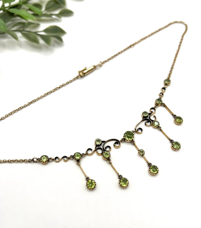A yellow gold swag necklace with peridot drops