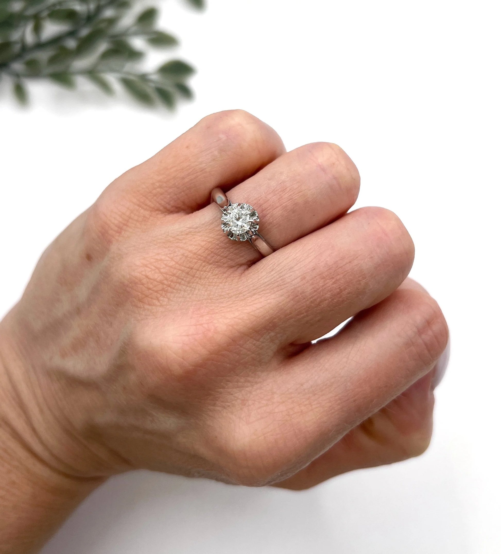 A solitaire round diamond ring in white gold, modelled on a hand