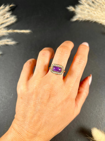 A cabochon amethyst and pearl halo cluster ring in gold, modelled on a hand