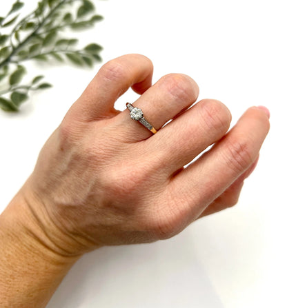 A diamond engagement style ring in yellow gold and platinum, modelled on a hand