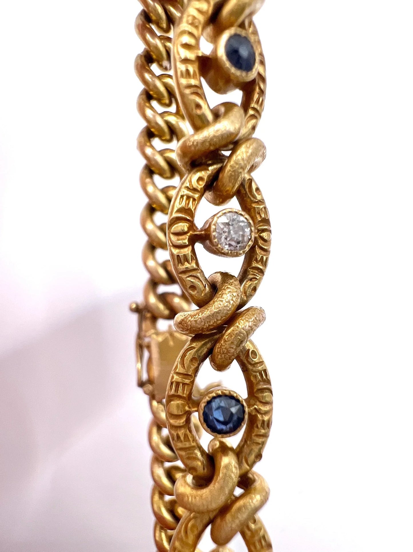 A sapphire and diamond fancy curb link bracelet in yellow gold