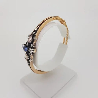 Antique Victorian Natural Sapphire and Old Cut Diamond Bangle Bracelet; central oval faceted natural sapphire surrounded by two white old-cut diamonds and two foiled pink rose-cut diamonds