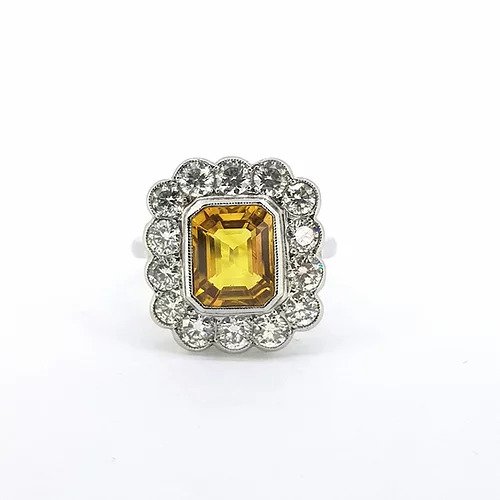 Yellow Sapphire and Diamond Floral Cluster Ring; 3ct emerald-cut yellow sapphire surrounded by 1.45cts round brilliant-cut diamonds, in platinum