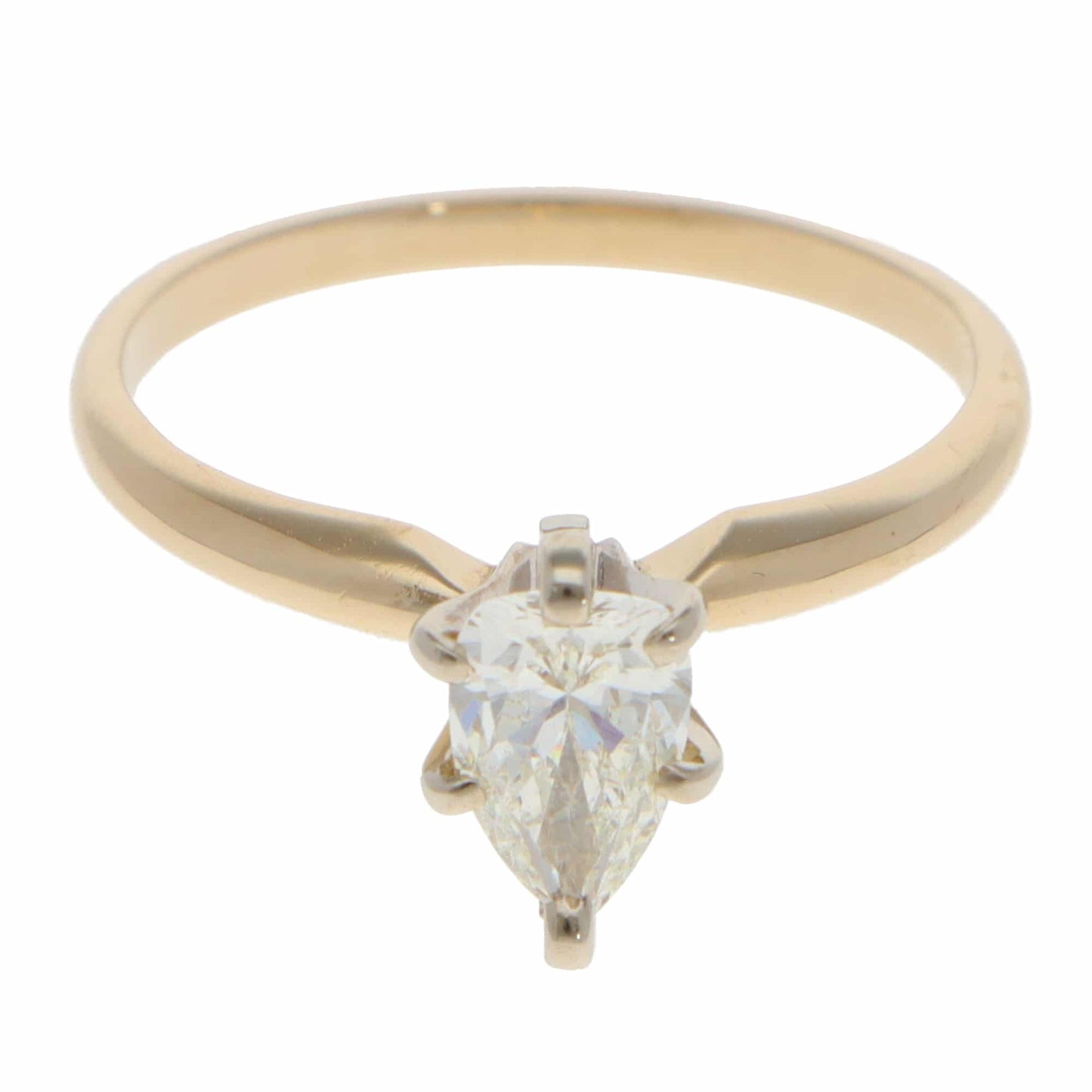 A single stone pear cut diamond ring in yellow and white gold, on a white background
