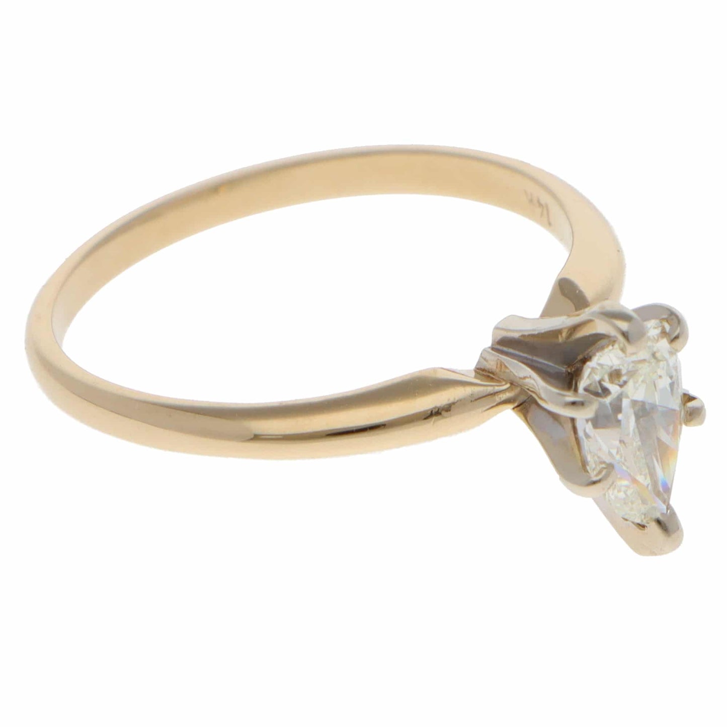 A single stone pear cut diamond ring in yellow and white gold, on a white background