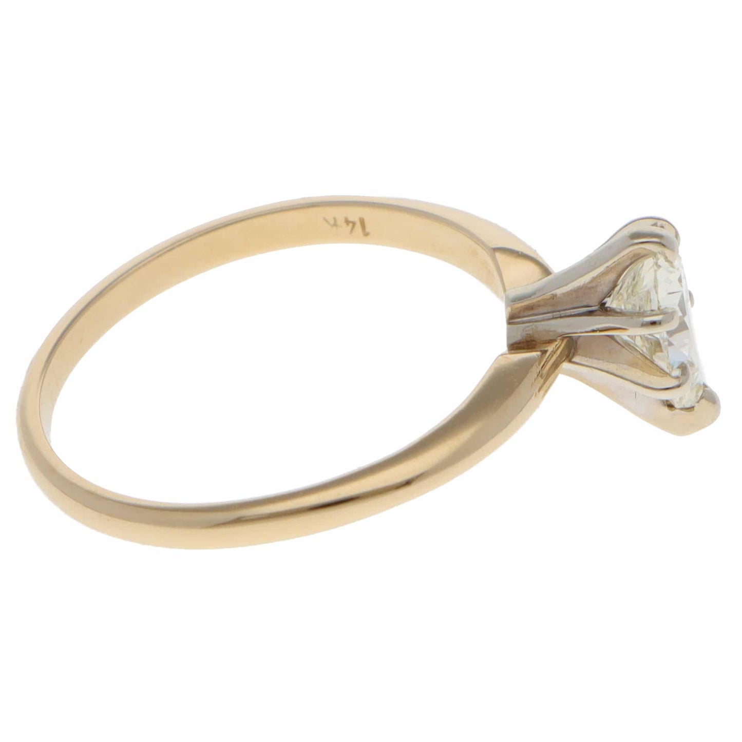 A single stone pear cut diamond ring in yellow and white gold, stamped 14K, on a white background