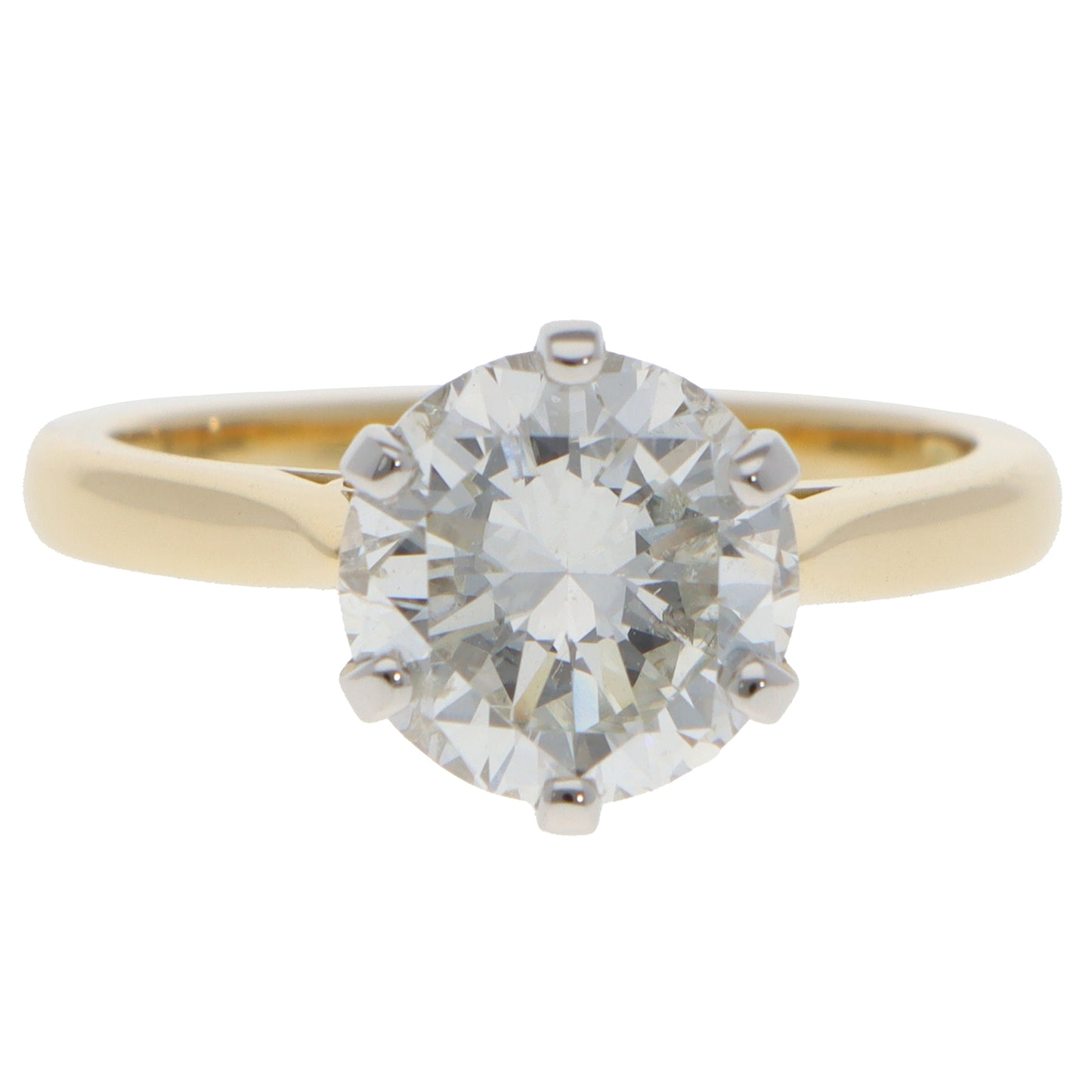 A single stone round brilliant cut diamond ring in yellow gold and platinum, on a white background