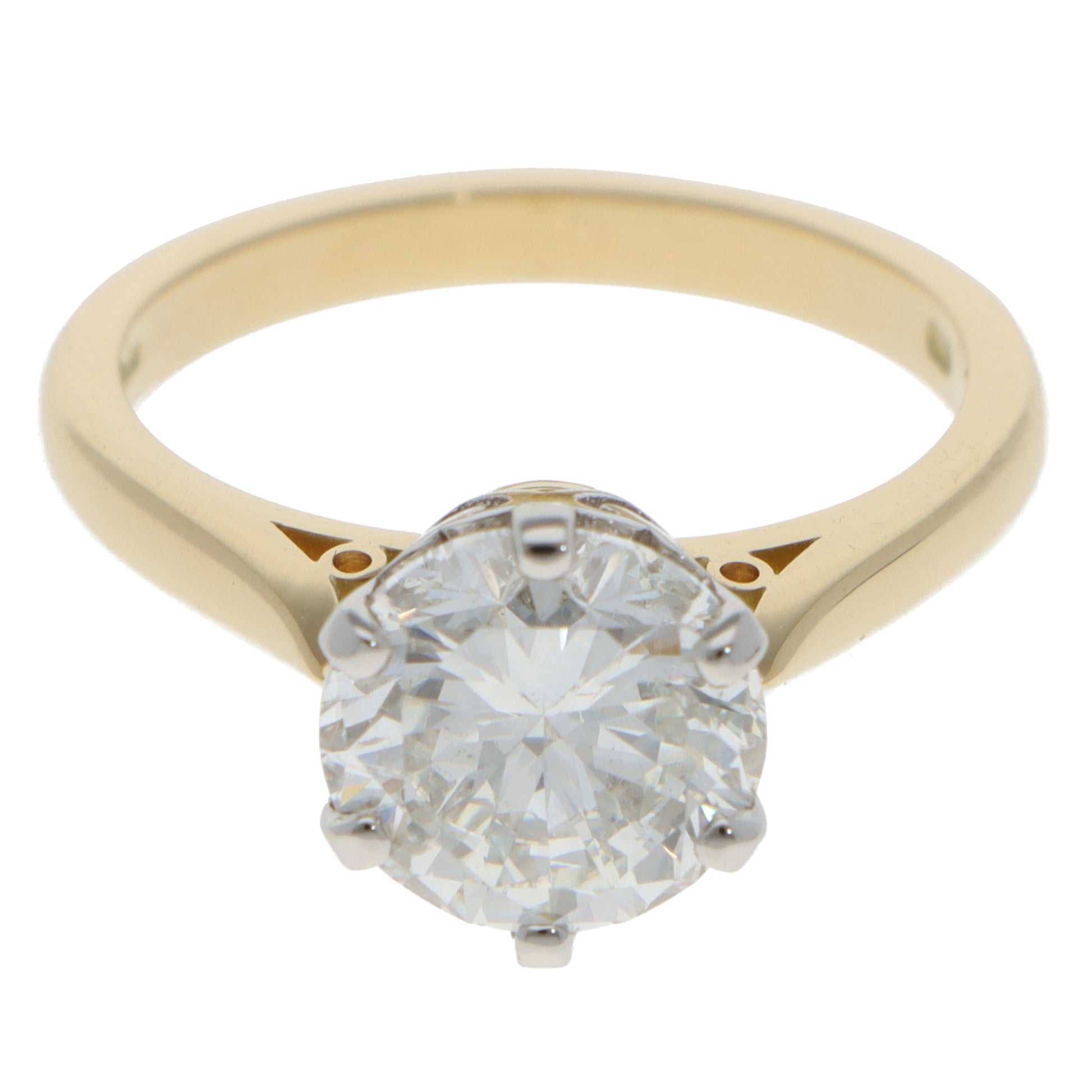 A single stone round brilliant cut diamond ring in yellow gold and platinum, on a white background