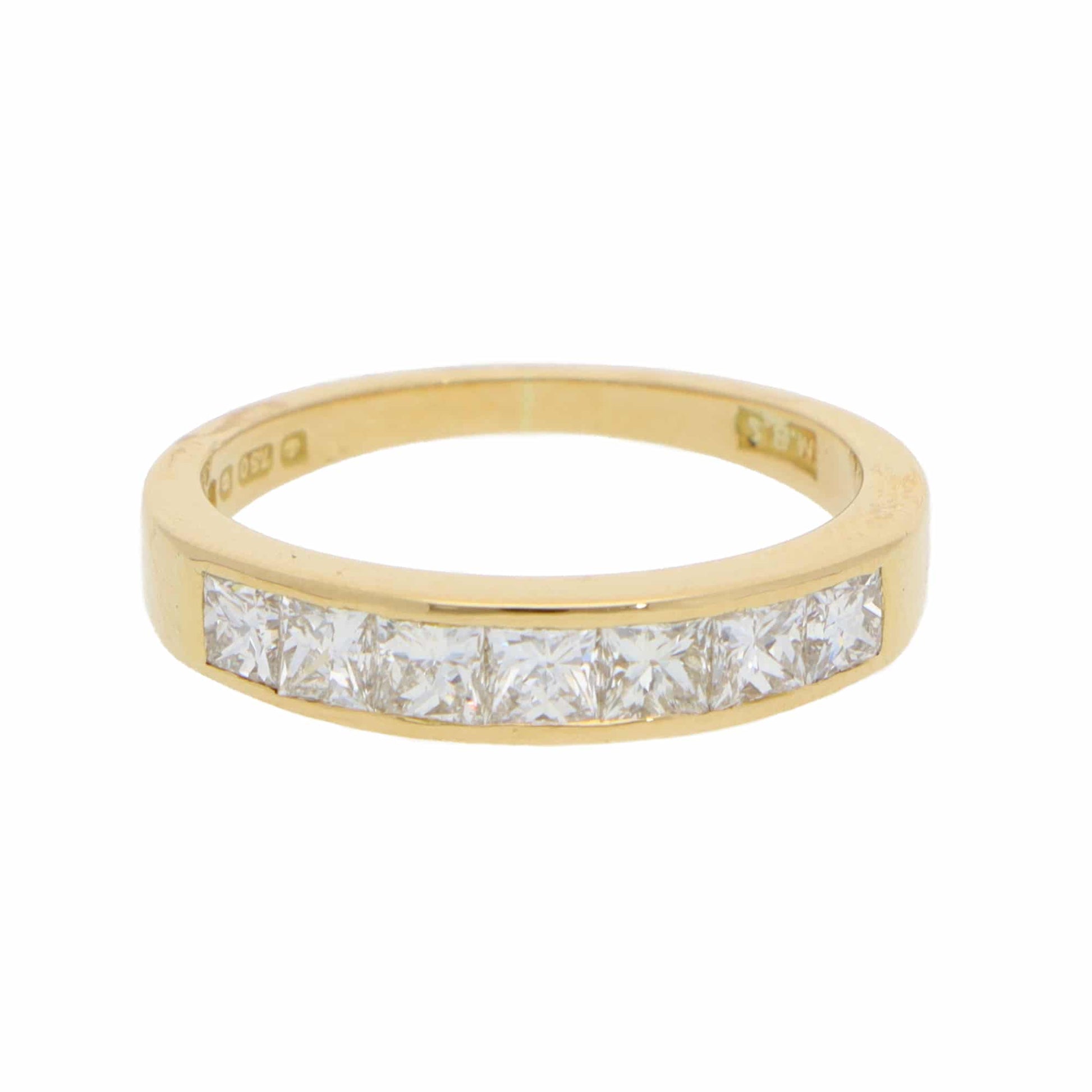 A yellow gold half eternity band ring with princess cut diamonds, on a white background
