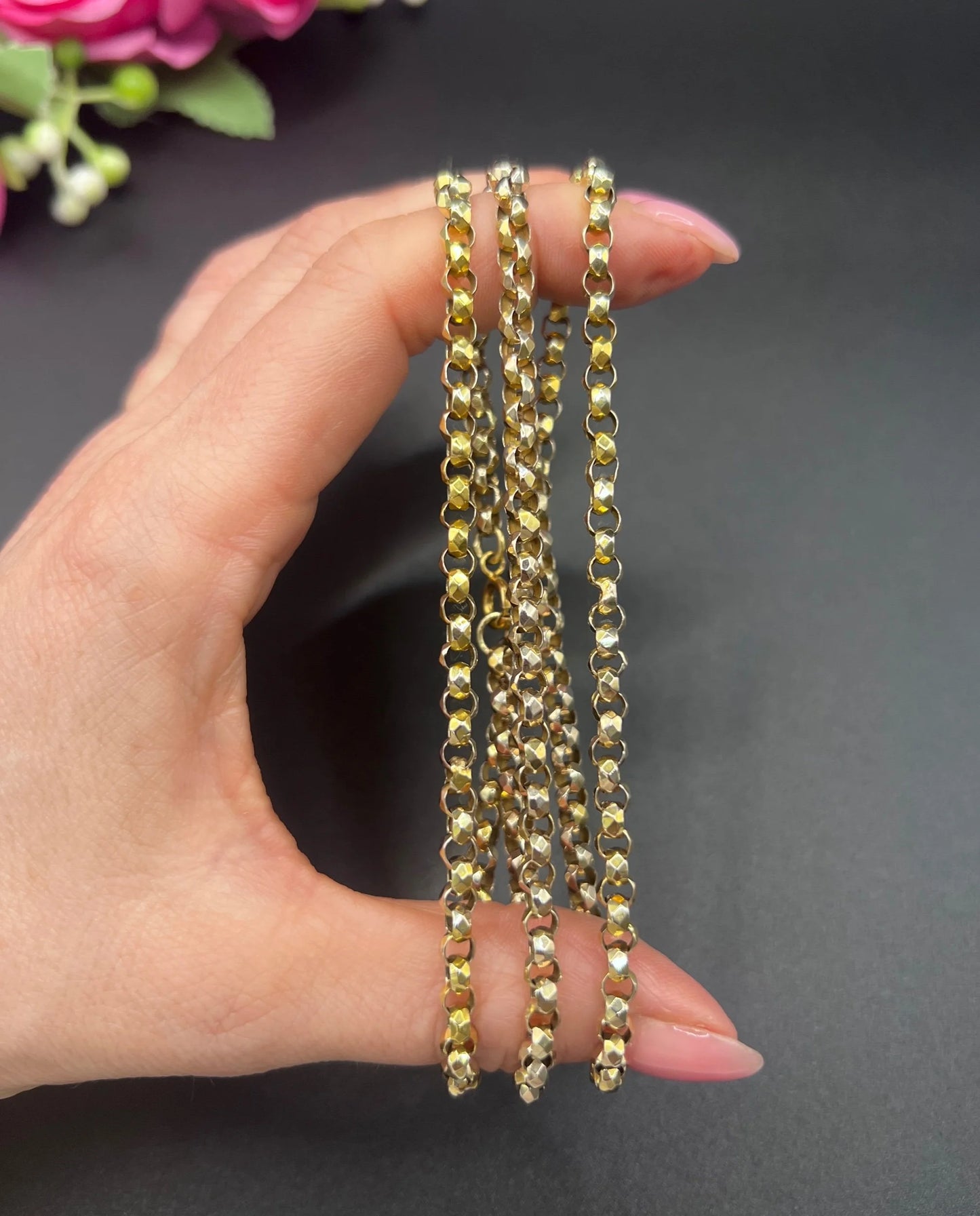 A yellow gold belcher link chain necklace, held in a hand