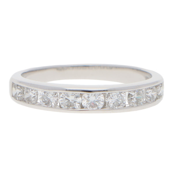 A brilliant cut diamond channel set half eternity band ring, on a white background