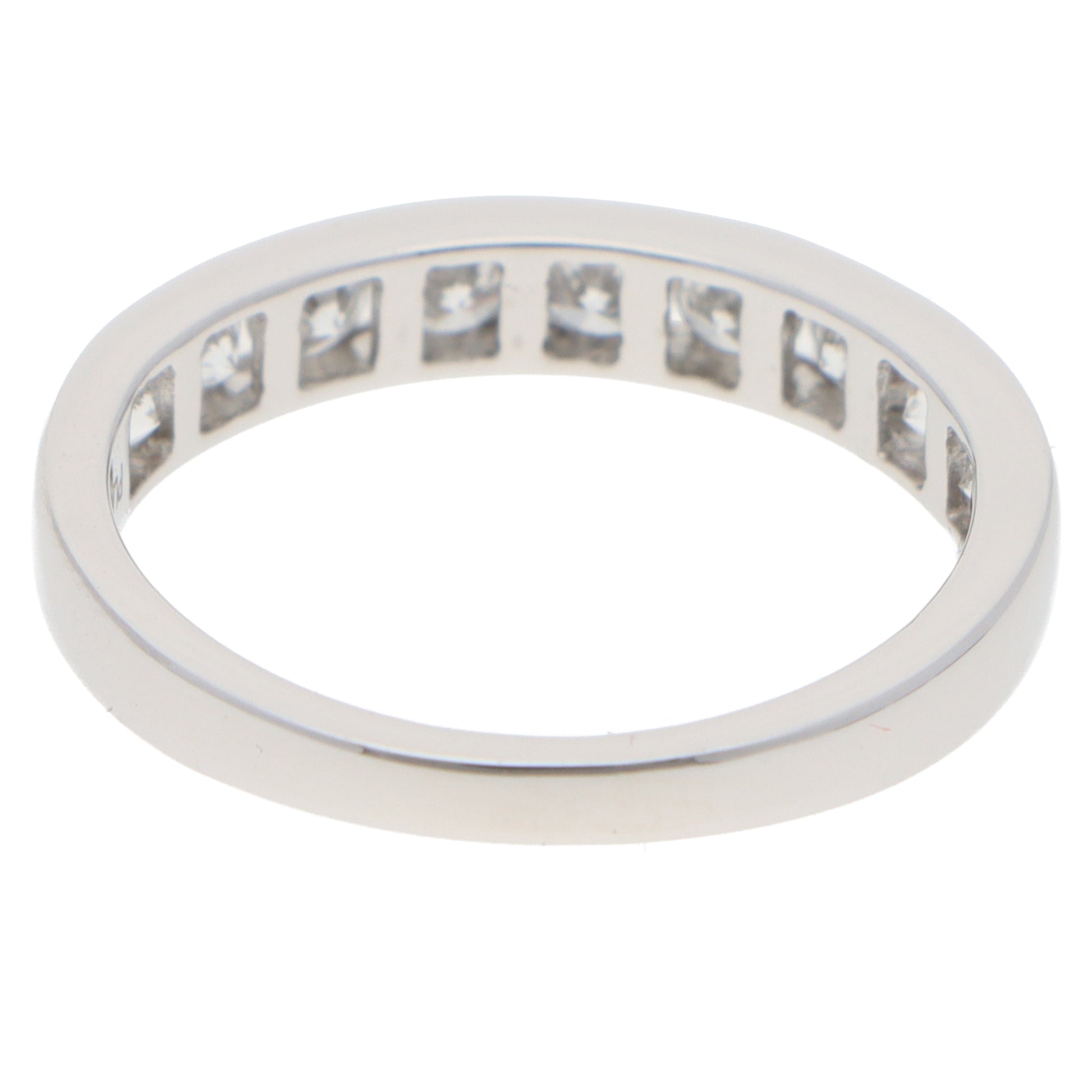 A brilliant cut diamond channel set half eternity band ring, on a white background