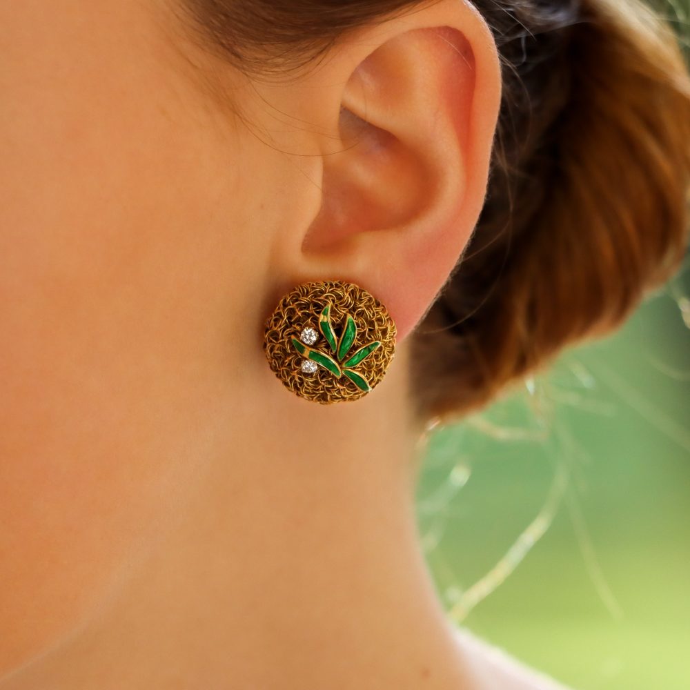 A pair of gold wire work clips earrings set with enamel leaves and diamonds.