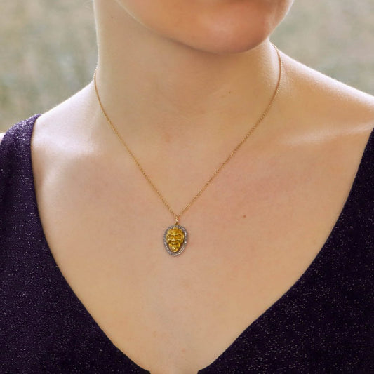 Joker face pendant set in gold with diamonds in platinum.