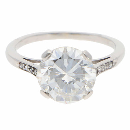 A large round brilliant cut diamond ring in platinum, on a white background