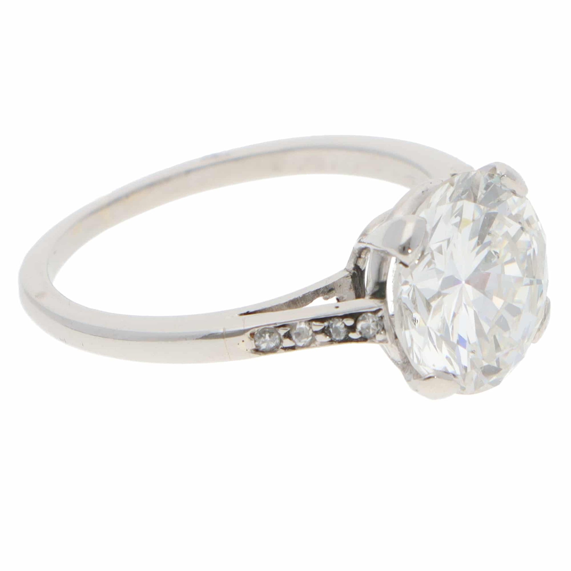 A large round brilliant cut diamond ring in platinum, on a white background