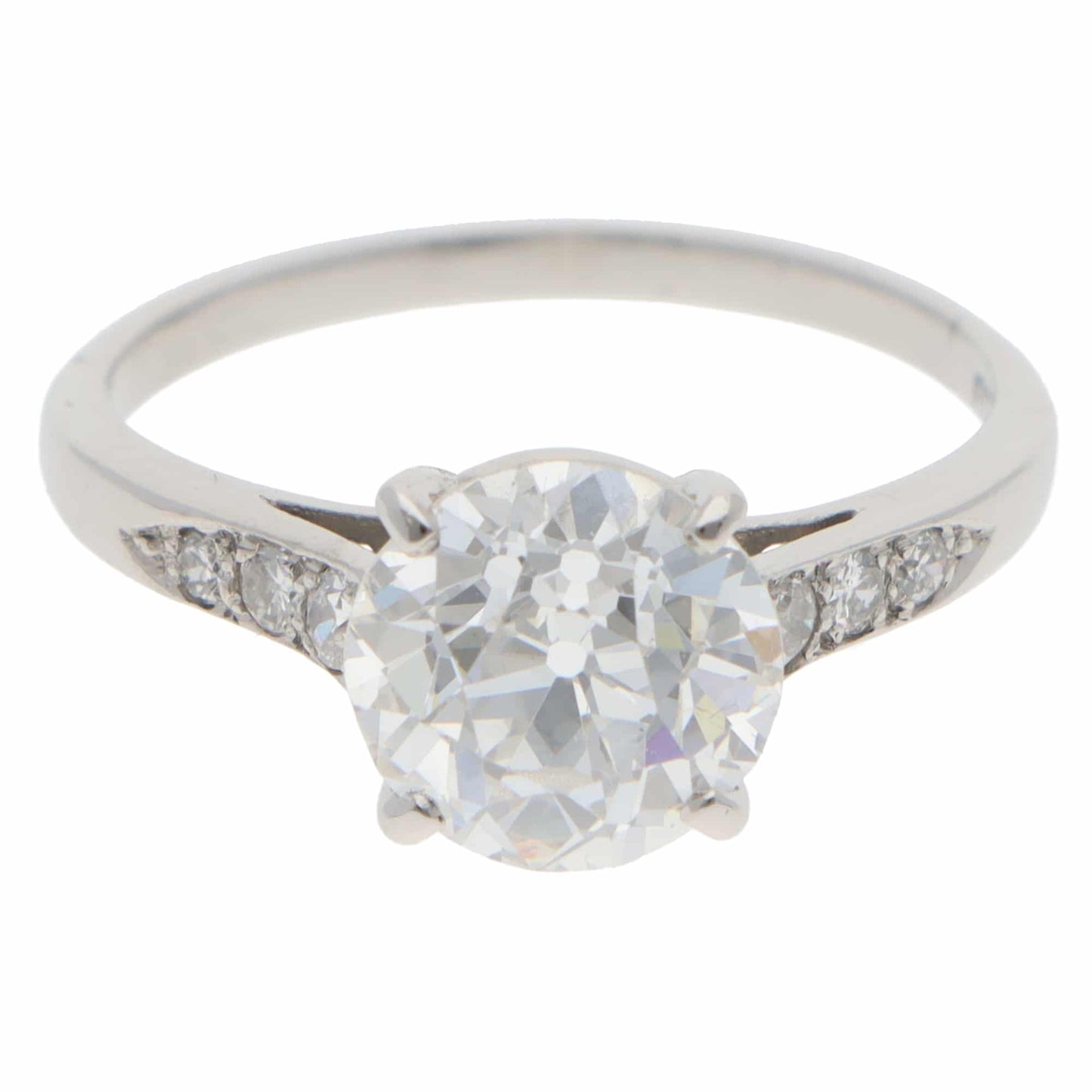 A round old cut diamond ring with diamond shoulders in platinum, on a white background