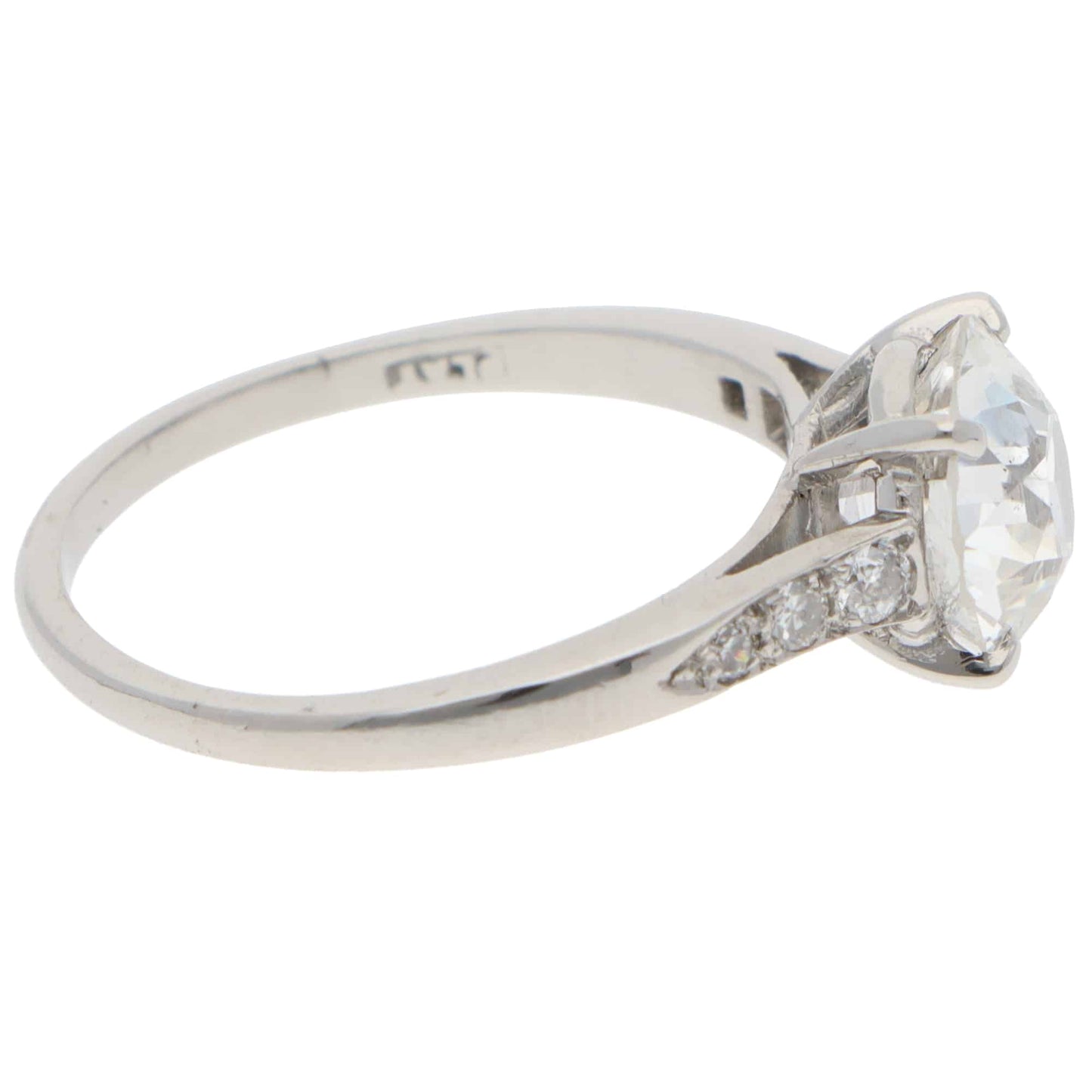 A round old cut diamond ring with diamond shoulders in platinum, stamped PLAT, on a white background