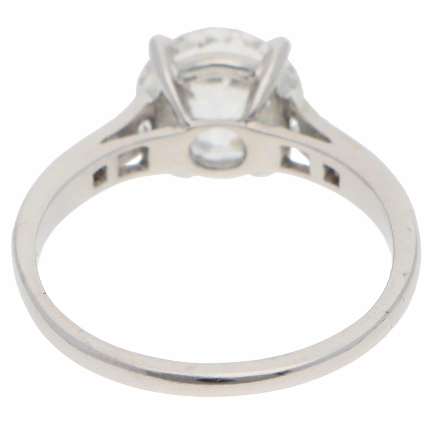 A round old cut diamond ring with diamond shoulders in platinum, on a white background