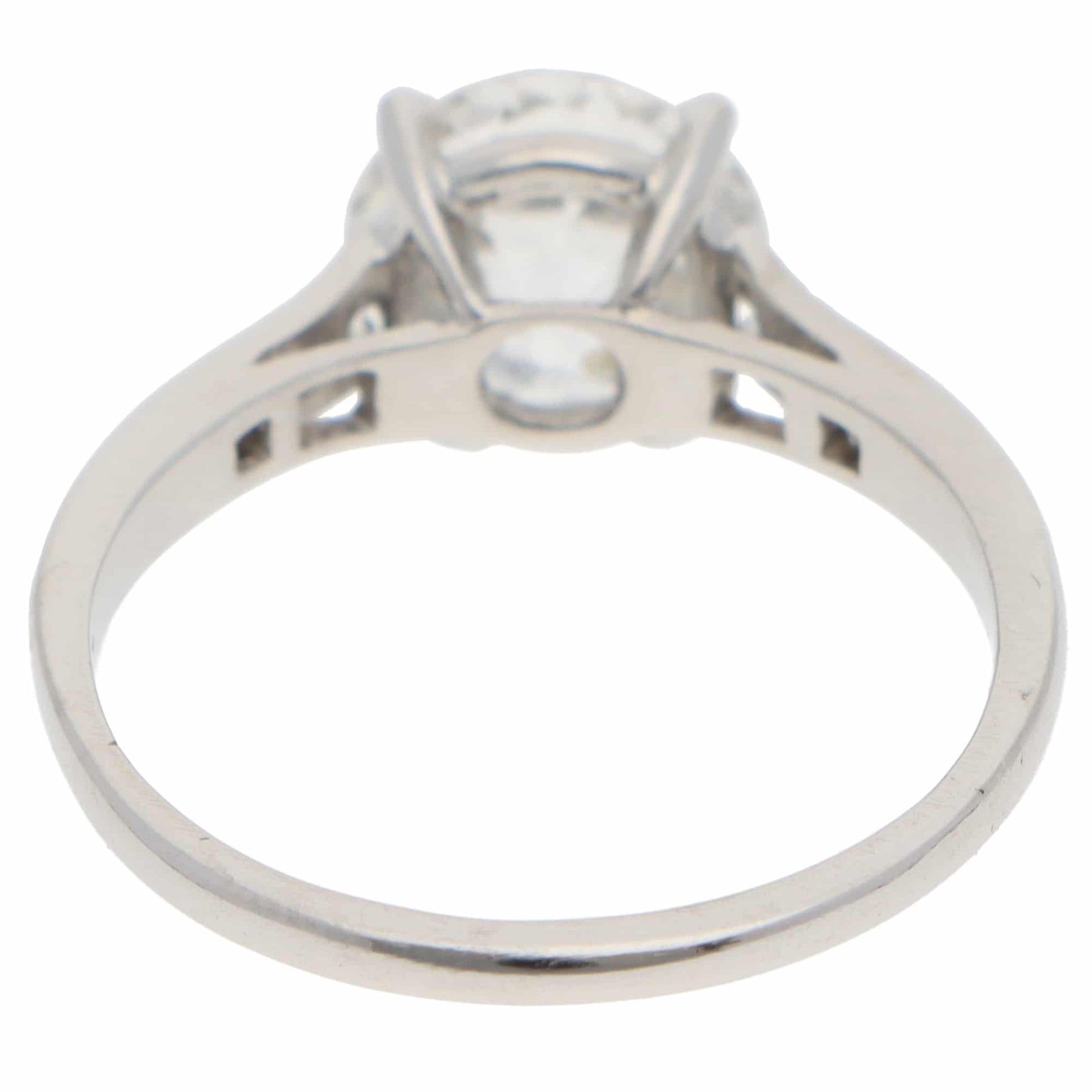 A round old cut diamond ring with diamond shoulders in platinum, on a white background